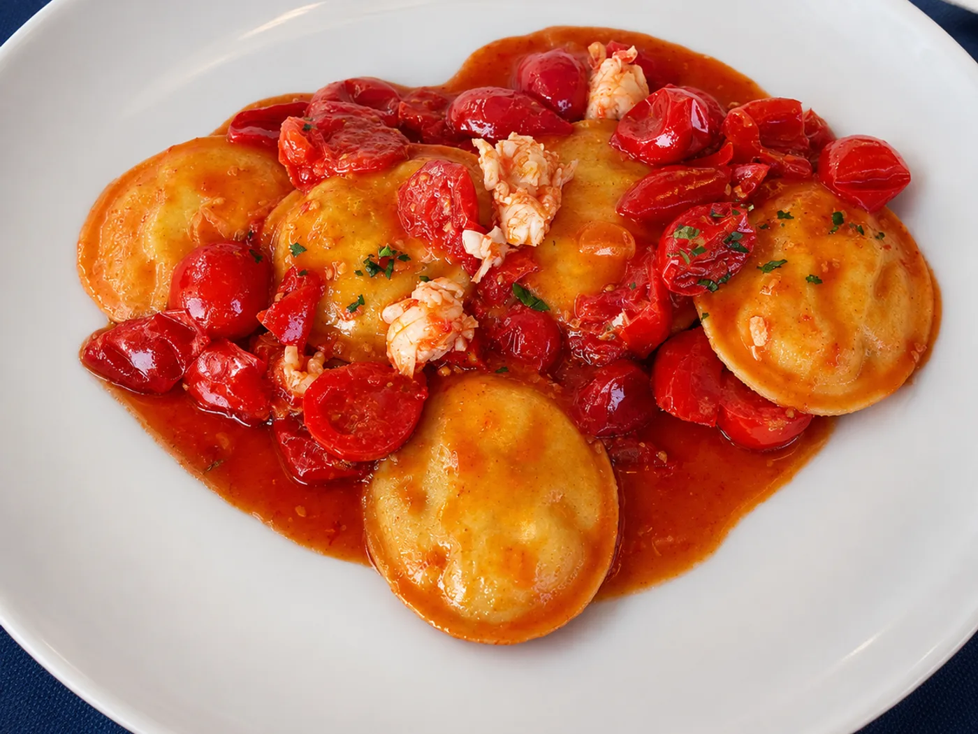 Ravioli con pomodorini e scampi serviti al tavolo
